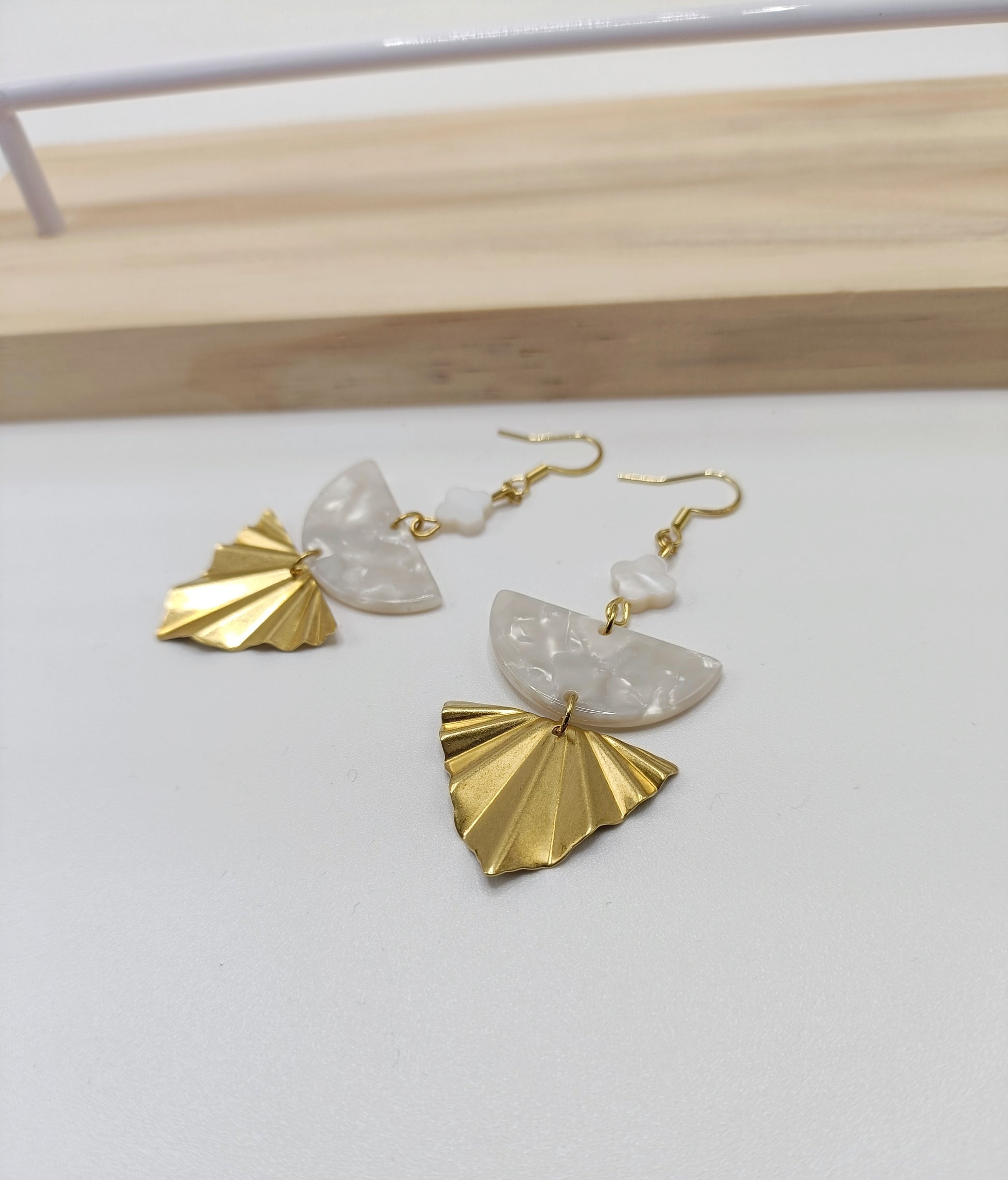 Boucles d'oreilles dorées triangles géométriques, acétate blanc et fleurs blanches en nacre.