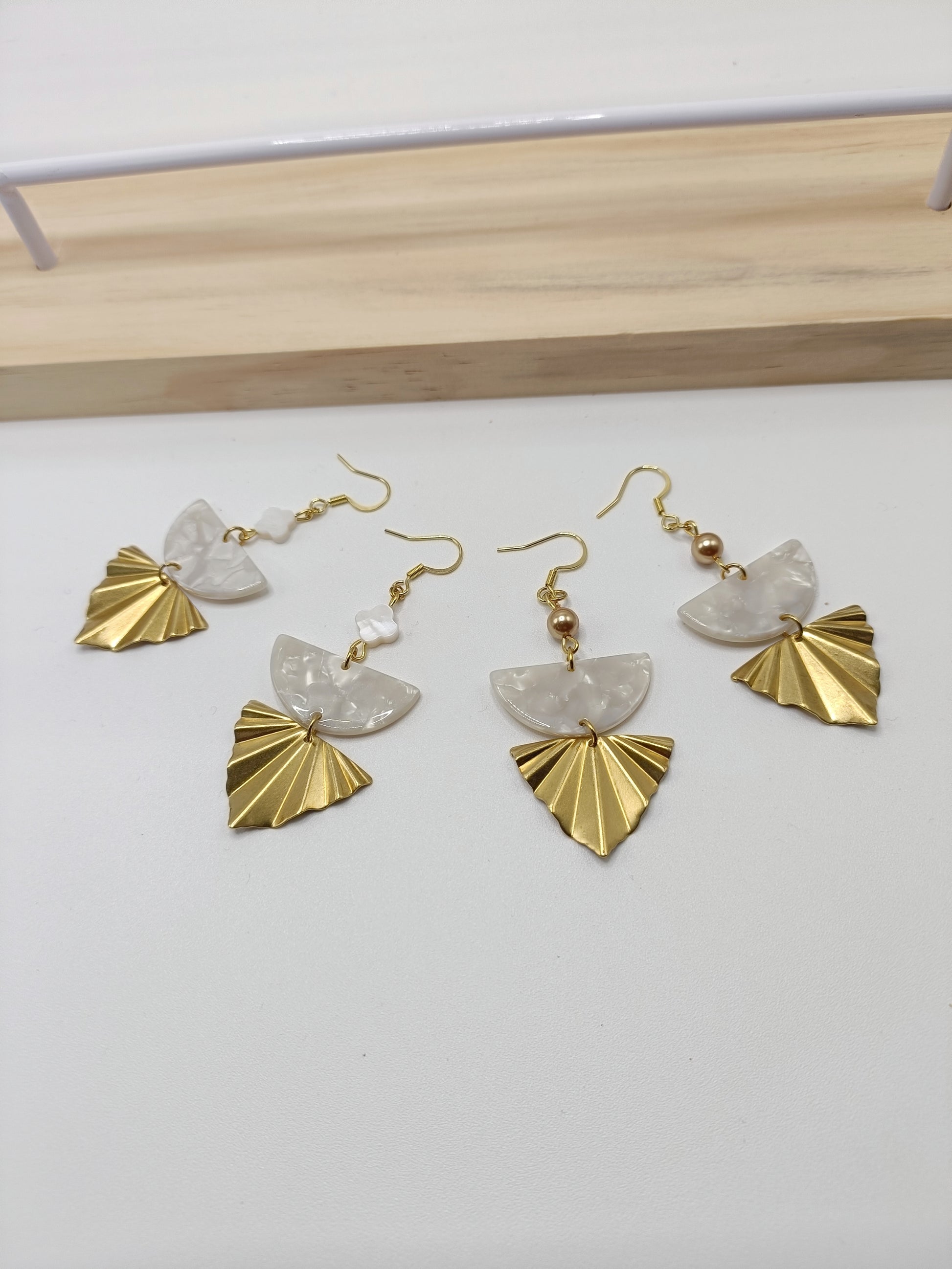 Boucles d'oreilles dorées triangles géométriques, acétate blanc et fleurs nacre blanches.